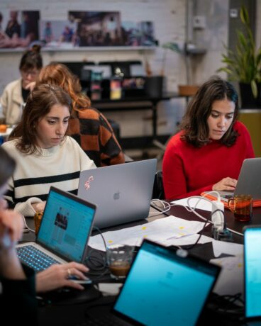 Photographie de 2 apprenantes concentrées pendant l'atelier sur figma avec l'intervenant en formation UI Design : Kevin Mercier