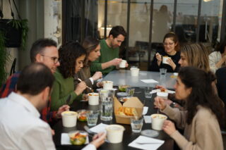 Photo de l'équipe en train de déjeuner, sur la grande table située dans l'atelier du Laptop.