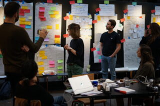 Participants du Design Sprint en train de déplacer des postits.